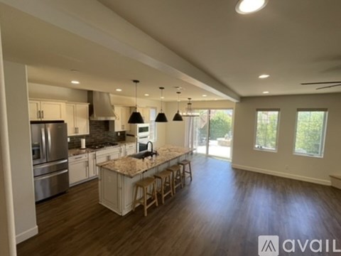 A modern kitchen with wooden floors and a large island in the middle.