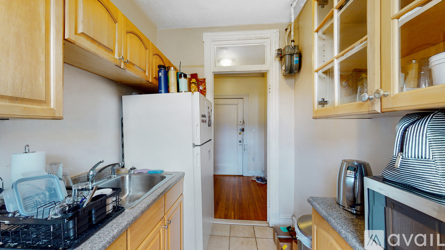 A kitchen with wooden cabinets and a white refrigerator.