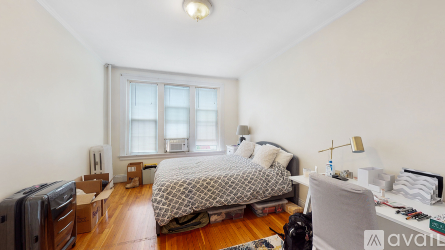 A bedroom with a bed, a couch, and a window.