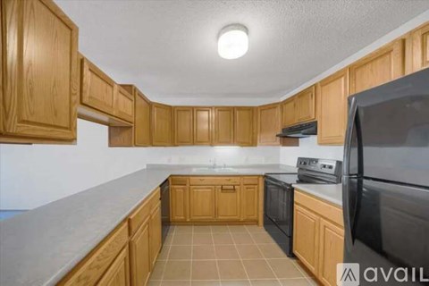 A kitchen with wooden cabinets and black appliances.