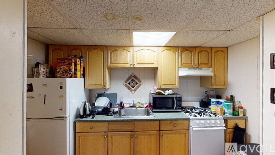 A kitchen with wooden cabinets and a white refrigerator.