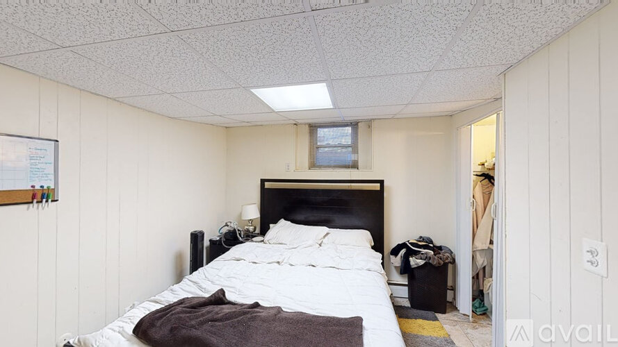 A bedroom with a bed, nightstand, and window.