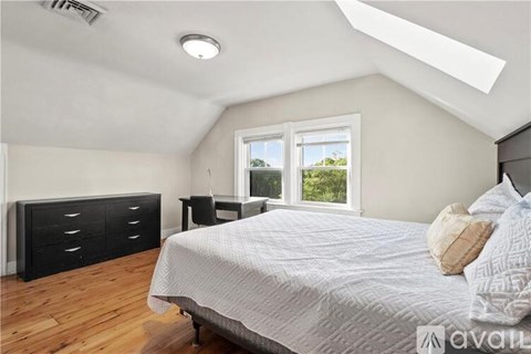 A bedroom with a bed, dresser, and window.