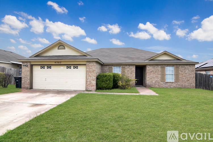A house with a garage and a driveway in front of it.