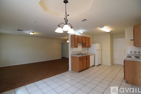 A kitchen with wooden cabinets and a white tile floor.