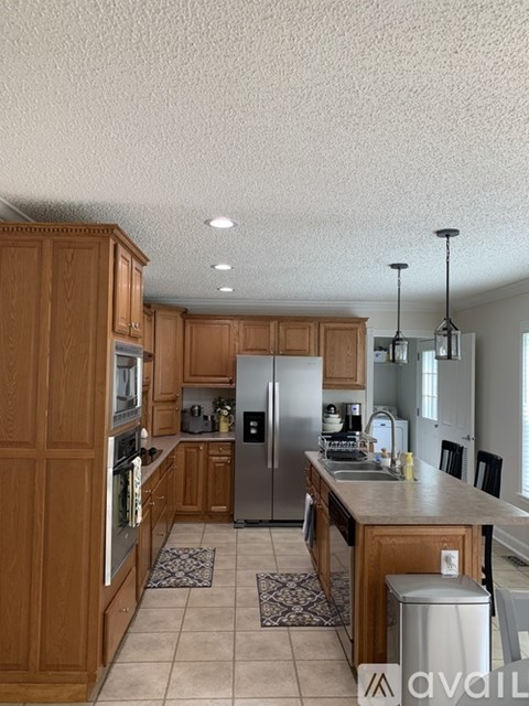 A kitchen with wooden cabinets and a stainless steel refrigerator.