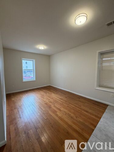 A room with wooden flooring and a window.