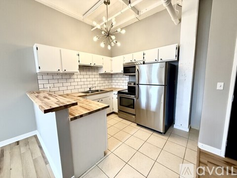 A kitchen with a wooden counter top and stainless steel appliances.
