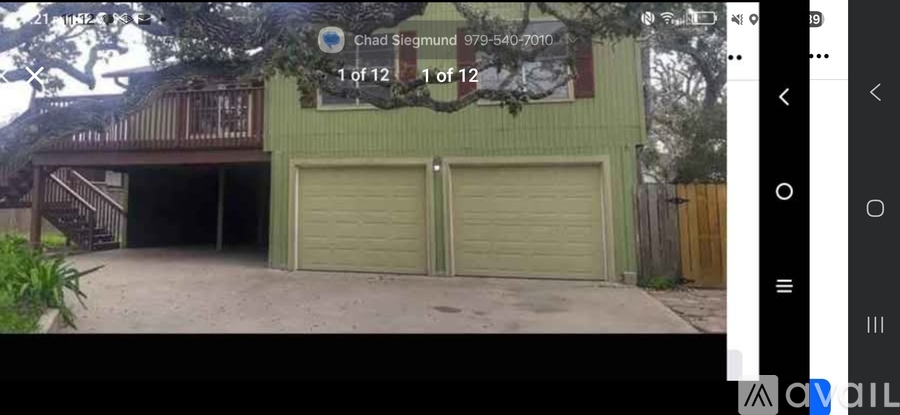 A green house with a closed grey garage door.