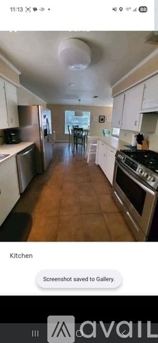A kitchen with white cabinets and a black stove top.