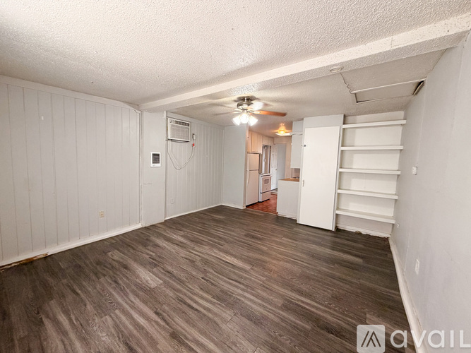 A room with wooden flooring and white walls.