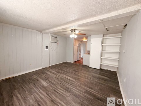A room with wooden flooring and white walls.