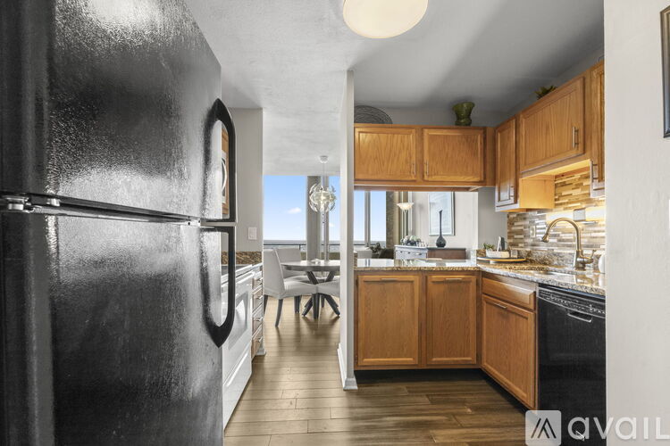 A kitchen with a black refrigerator and wooden cabinets.