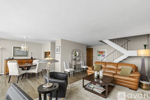 A living room with a brown leather couch and a coffee table.