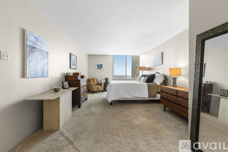 A bedroom with a large bed, a desk, and a chair.