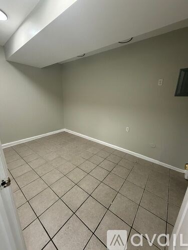 A room with beige tiled flooring and white walls.