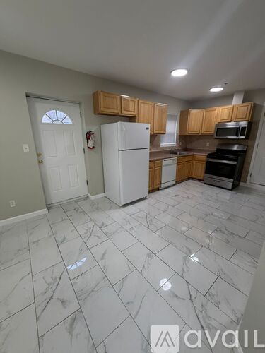 A kitchen with a white refrigerator and a white door.