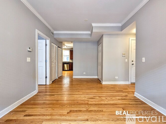 A long hallway with wooden floors and white walls.