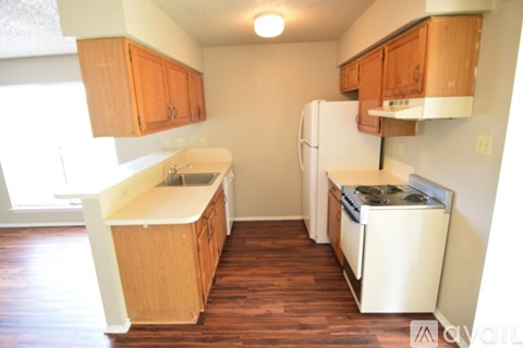 A kitchen with wooden cabinets and a white refrigerator.