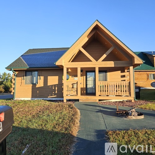 A wooden house with a green roof and a porch.