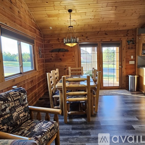 A wooden dining room with a table and chairs.