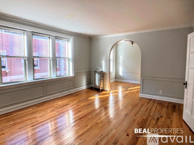 A room with wooden floors and a large archway.
