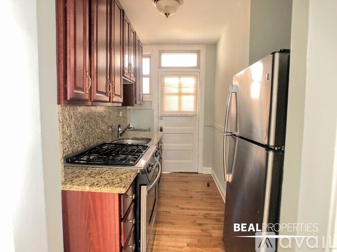 A kitchen with wooden cabinets and a stainless steel refrigerator.