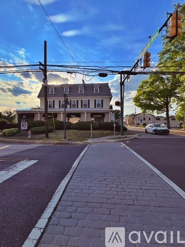 A street view with a car on the road and a building in the background.