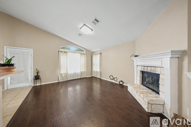 A living room with a fireplace and a wooden floor.