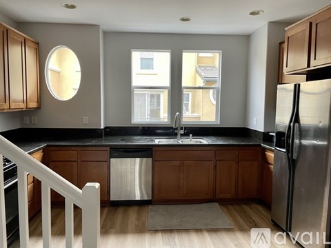 A kitchen with wooden cabinets and a black countertop.