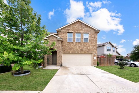 A house with a garage and a driveway in front of it.