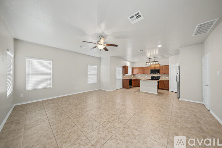 A spacious living room with a ceiling fan and lighting fixture.