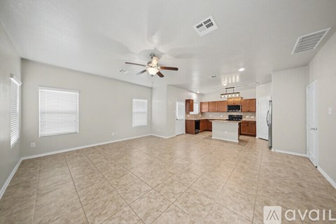 A spacious living room with a ceiling fan and lighting fixture.