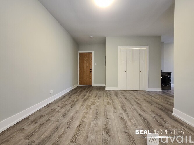 A room with a wooden floor and two doors.