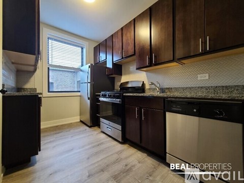 A kitchen with dark wood cabinets and stainless steel appliances.