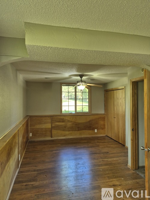 A room with wooden floors and a ceiling fan.