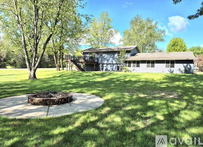 A house with a backyard and a fire pit.