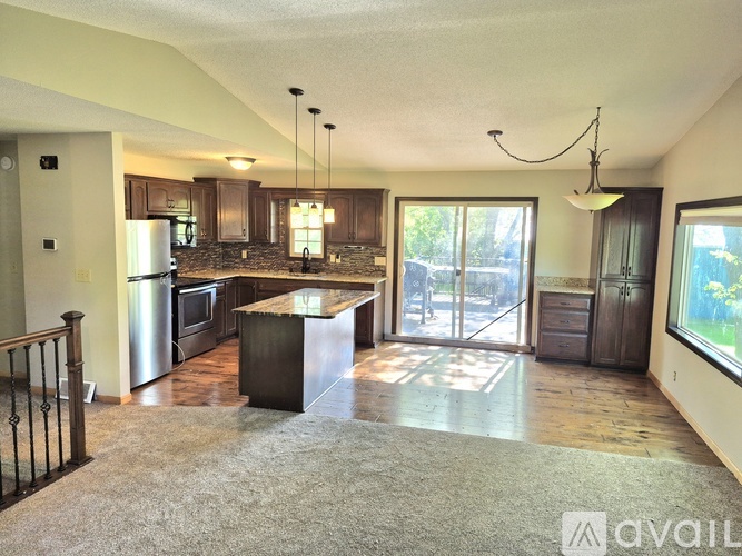 A kitchen with a refrigerator, microwave, and oven.