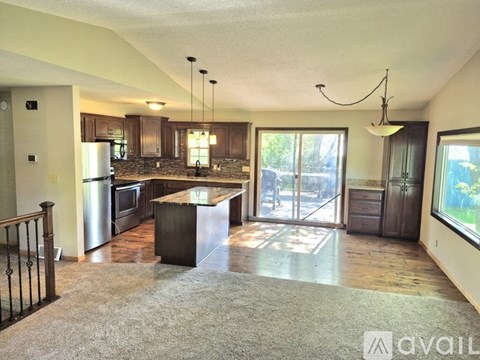 A kitchen with a refrigerator, microwave, and oven.