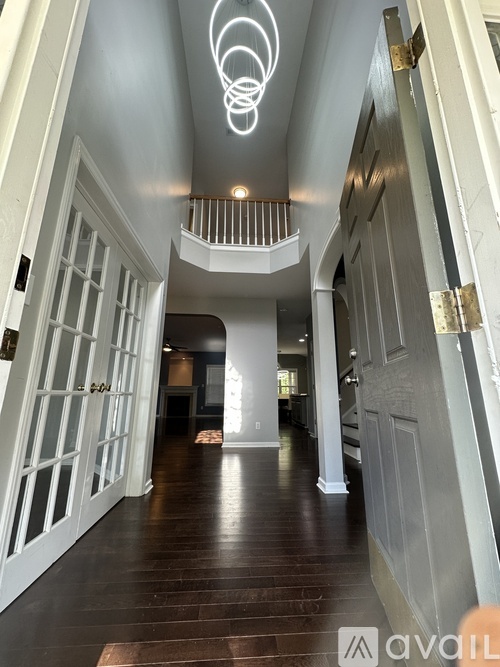 A hallway with a light fixture on the ceiling and a logo in the bottom right corner.