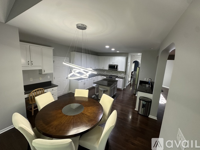A modern kitchen with a dining table and chairs.
