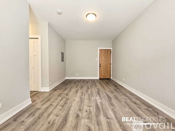 A room with a wooden floor and a door on the right side.