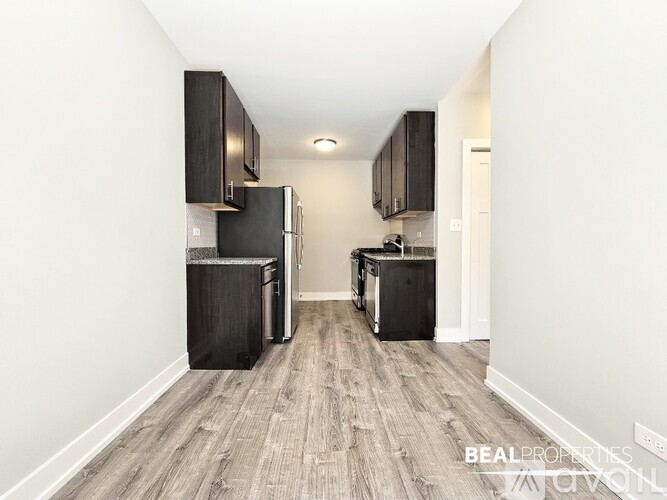 A kitchen with black appliances and cabinets in a white room.