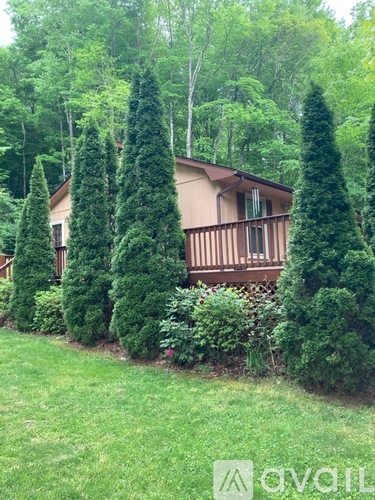 A house with a brown roof and a green lawn in front.