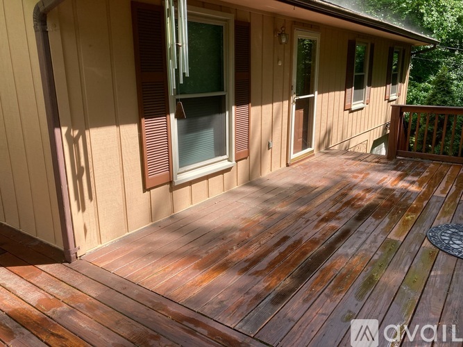 A wooden deck with a window and a door.