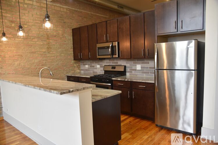 A kitchen with a refrigerator, microwave, and oven.