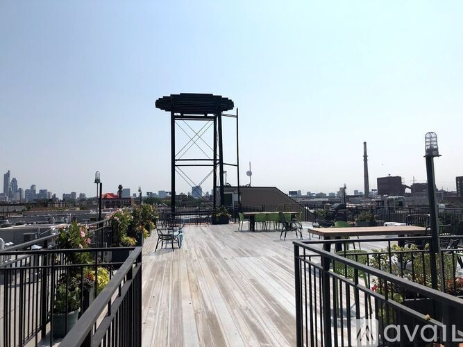 A wooden deck with a gazebo and metal railing overlooking a city skyline.
