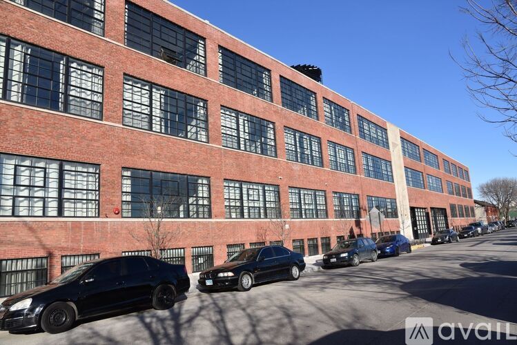 A row of cars parked in front of a red brick building.