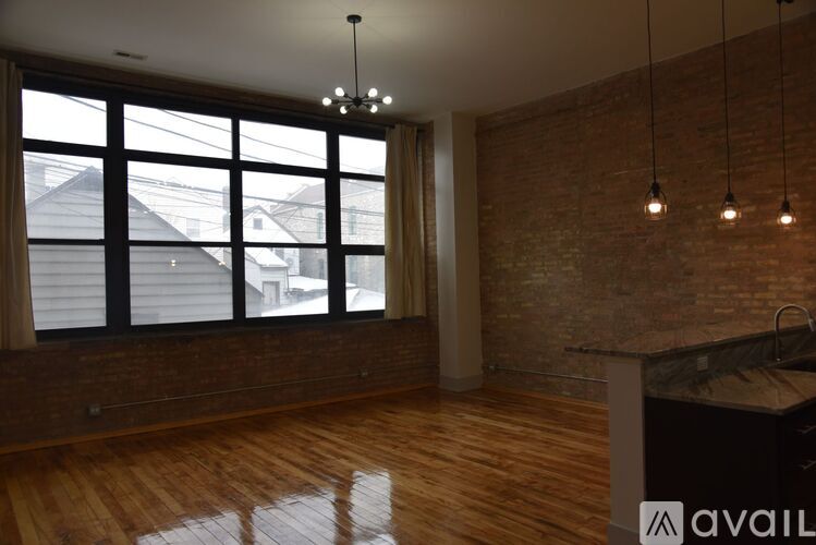 A room with wooden floors and a brick wall.