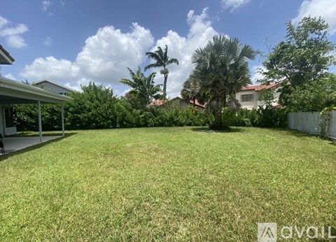 A backyard with a well-maintained lawn and a house in the background.